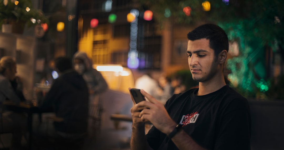 Man using a smartphone, representing dating app messaging, openers and text game