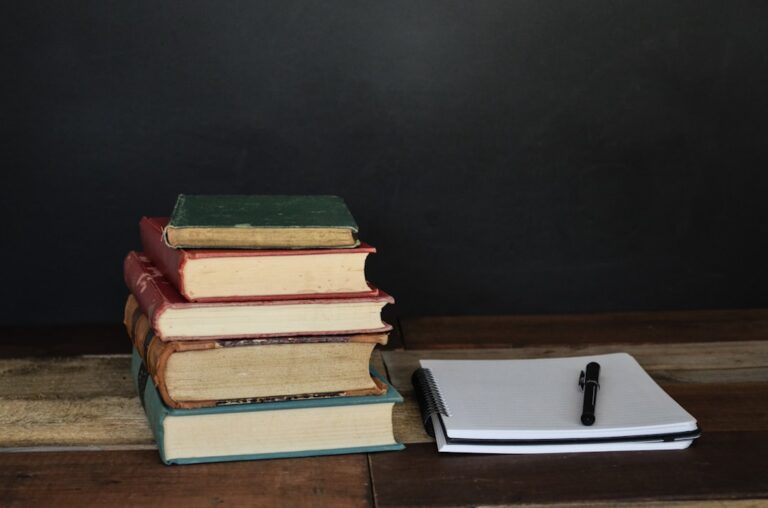 Stack of books on a desk, representing classic dating books, game systems and men's relationship theory
