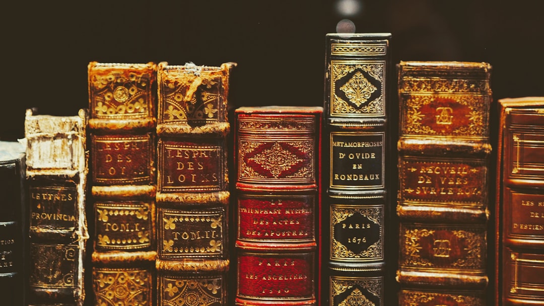 Stack of classic books representing the dating gurus, systems, and ideas that built modern game