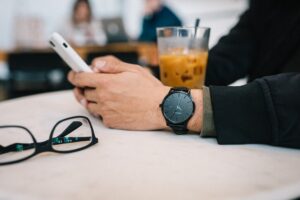 Man using a smartphone while having coffee, illustrating intentional dating app use