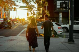 Couple walking together in a city at sunset, illustrating dating abroad as a real relationship rather than a marketplace