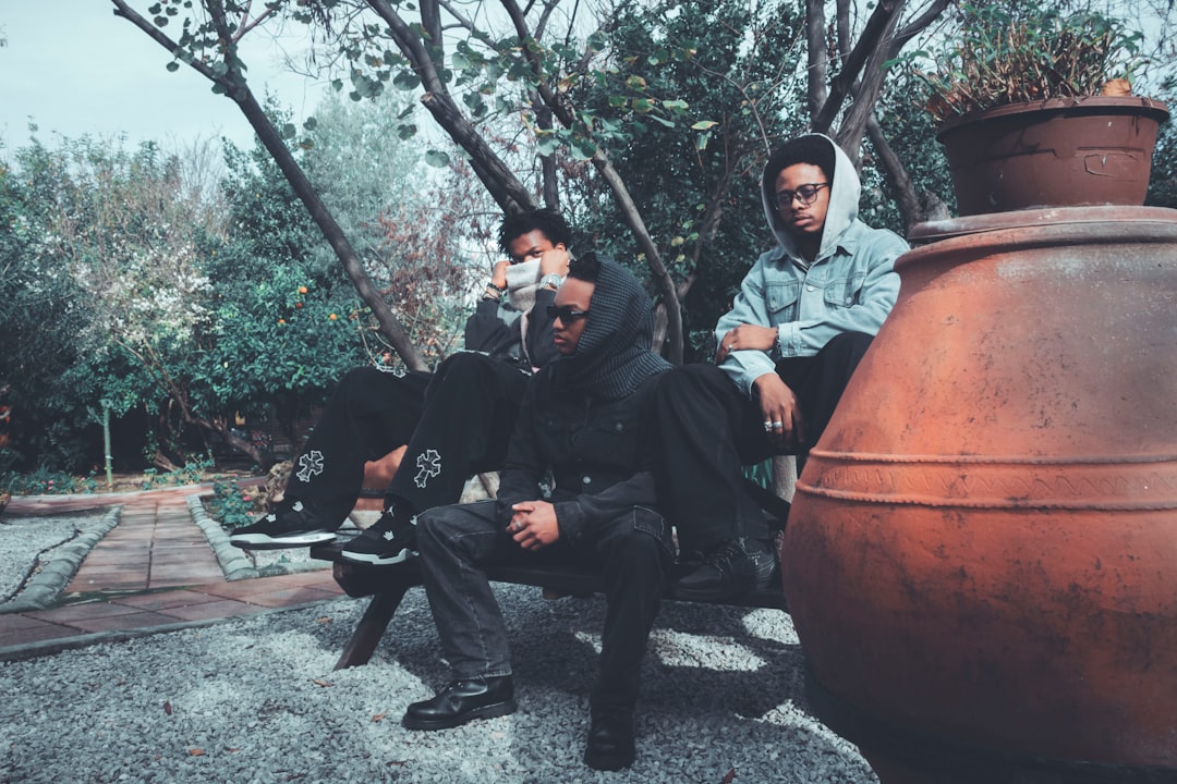 Three adult men sitting together outdoors, illustrating friendship, social support and regular in-person connection