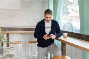 Man using a smartphone while seated in a coffee shop