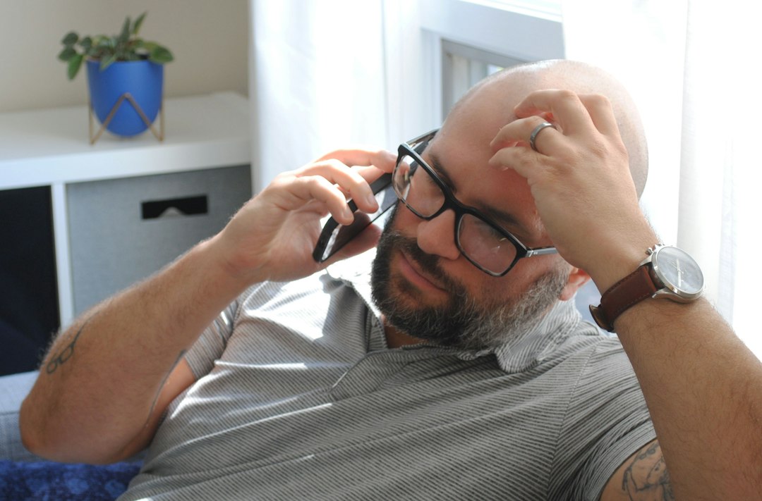A man looking frustrated while using a smartphone