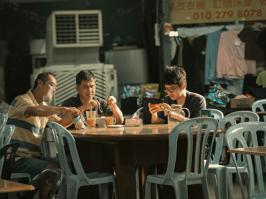 A man messaging on his phone at a cafe table