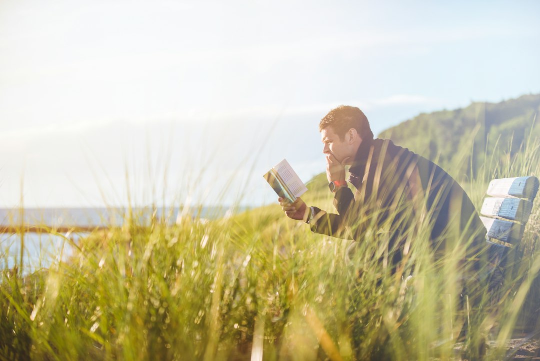 A man reading outdoors for personal development
