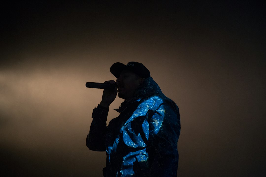A hip-hop performer silhouetted on stage